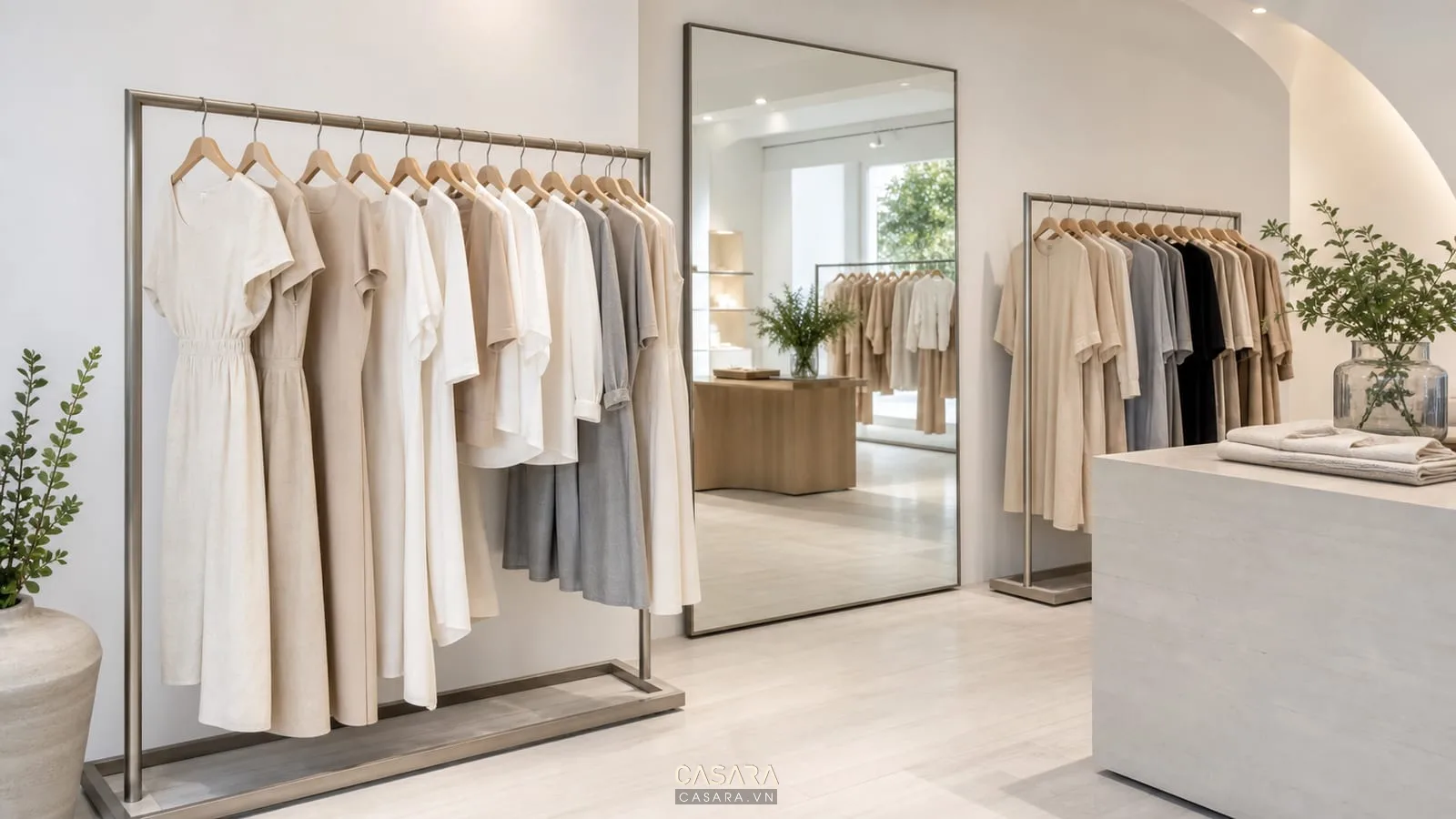 Mẫu shop quần áo nữ đẹp với gương bo góc và giá treo váy áo màu sáng