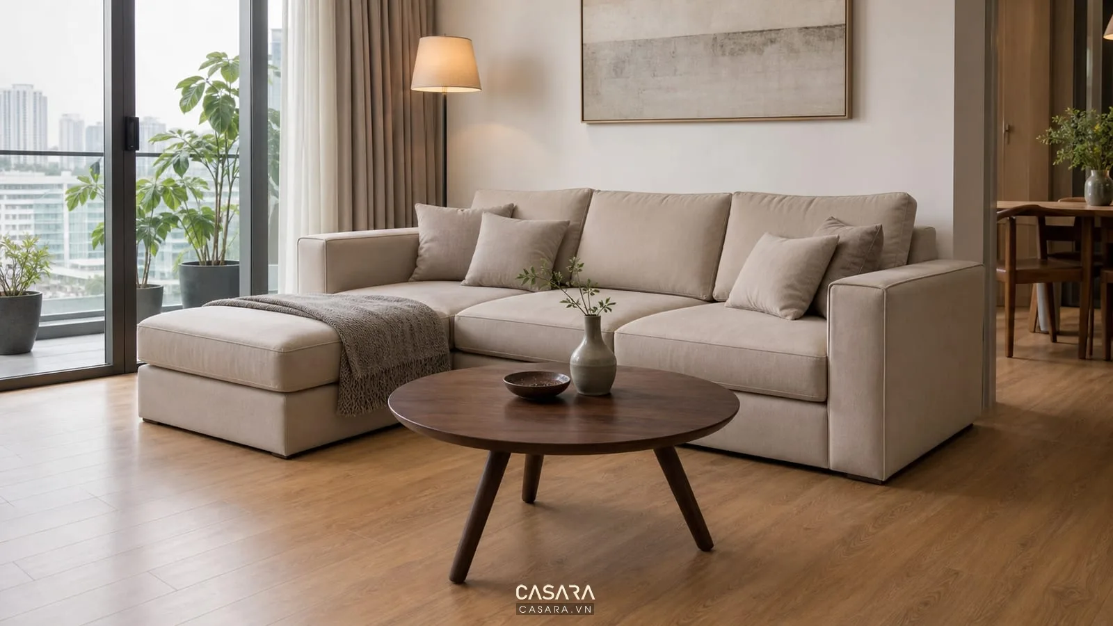 Bàn trà 3 chân mặt tròn trong phòng khách hiện đại với sofa và sàn gỗ