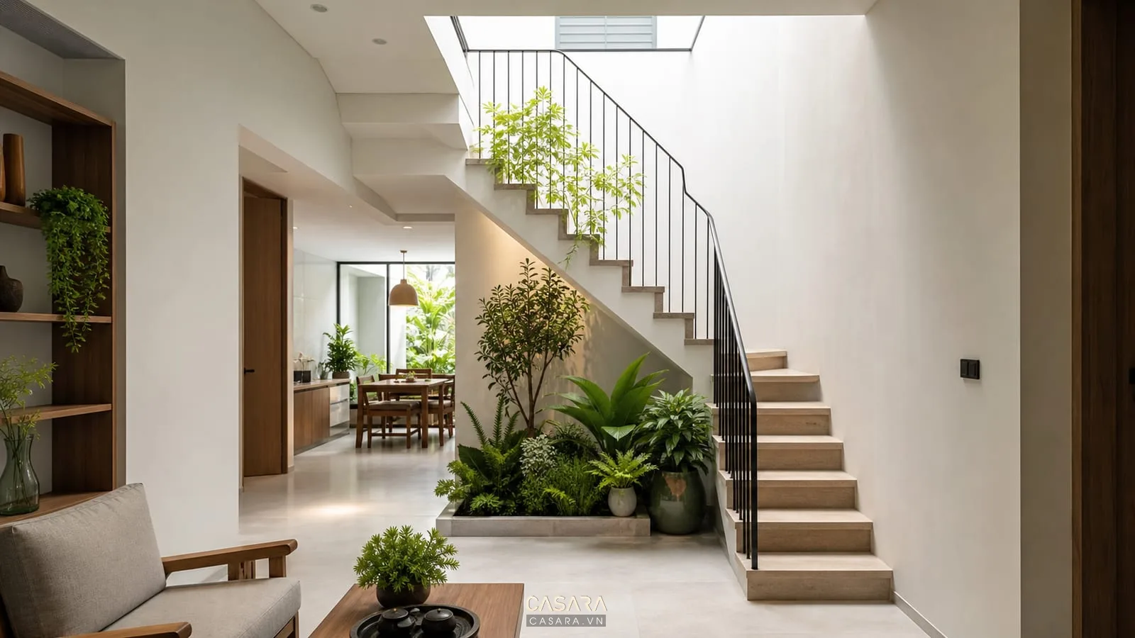 cầu thang nhà ống có giếng trời cây xanh và lan can sắt mảnh