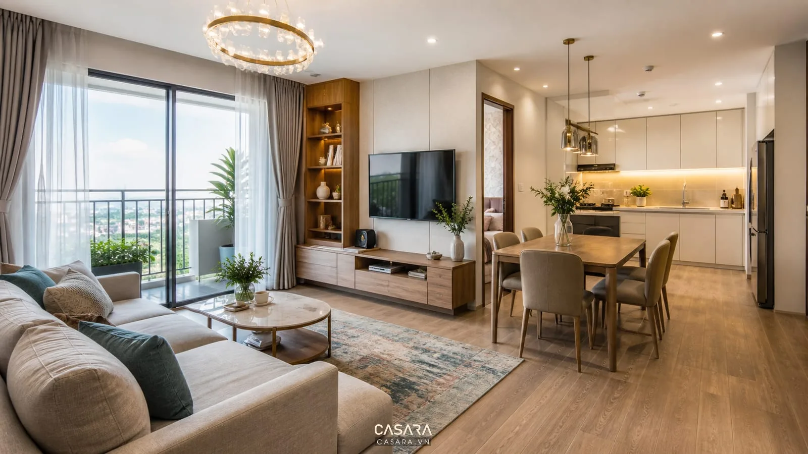 Thiết kế Vinhomes Ocean Park phòng khách liên thông bếp với sofa chữ L, kệ tivi gỗ, bàn ăn và tủ bếp sáng màu