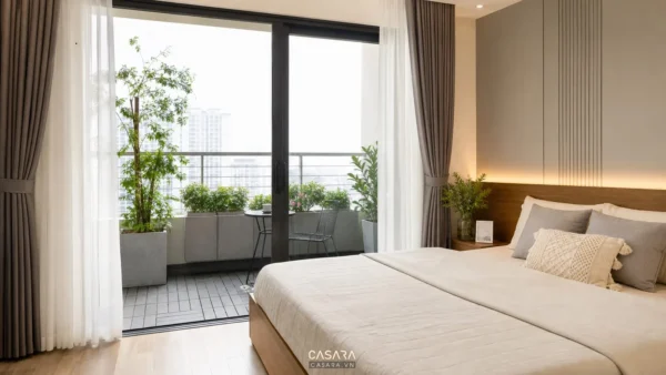 Phòng ngủ có cửa kính mở ra ban công nhỏ nhiều cây xanh