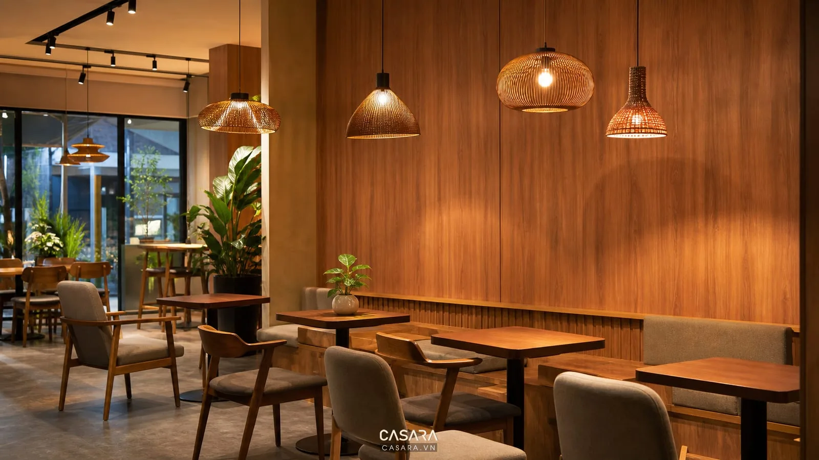 đèn thả ánh sáng ấm chiếu lên bàn ghế cafe và tường gỗ trong quán cafe