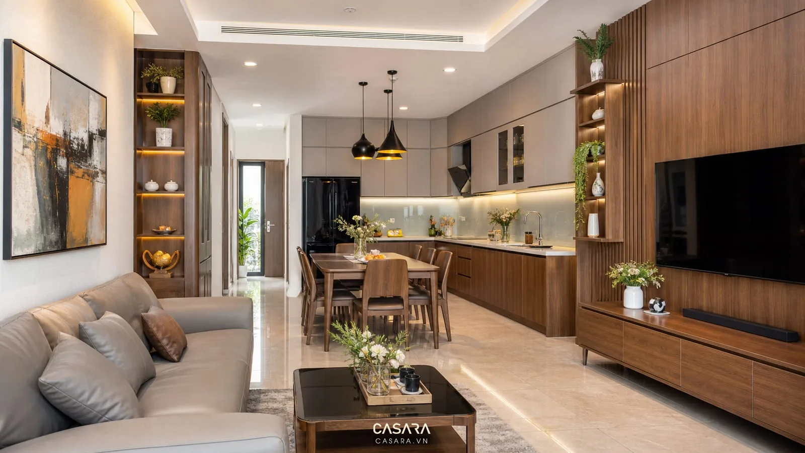 Thi công nội thất nhà ở khu phòng khách bếp với sofa, tủ tivi gỗ, bàn ăn, tủ bếp chữ L, mặt đá và đèn thả.