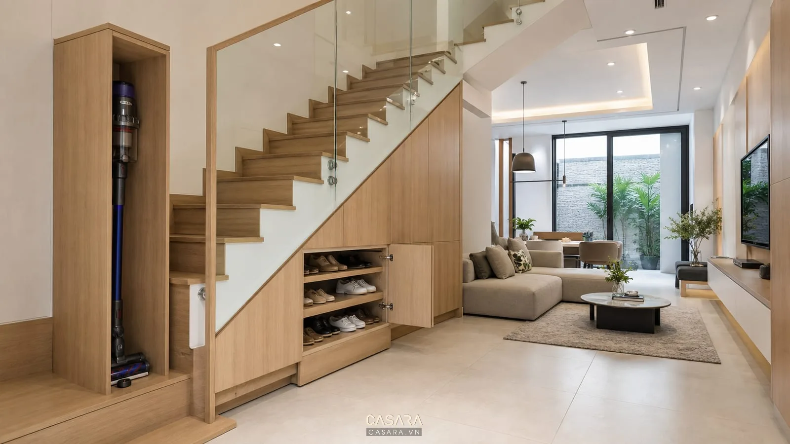 Thiết kế gầm cầu thang nhà ống với tủ lưu trữ kín màu gỗ sáng và cầu thang hiện đại