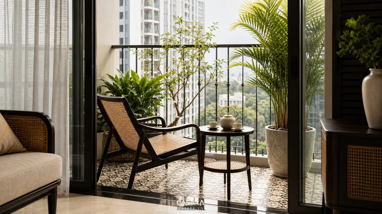 Ban công chung cư phong cách Indochine với ghế mây, bàn trà nhỏ và cây xanh nhiệt đới