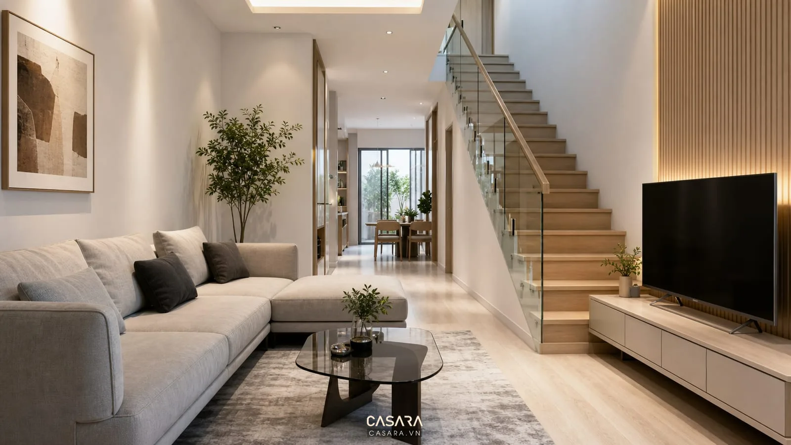 Thiết kế phòng khách đẹp nhà ống 5m với cầu thang dọc, sofa chữ L, kệ tivi thấp, lan can kính và sàn gỗ sáng