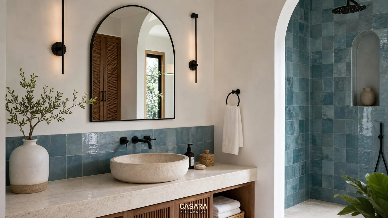 phòng tắm phong cách địa trung hải với gương vòm gạch xanh biển và lavabo đá sáng