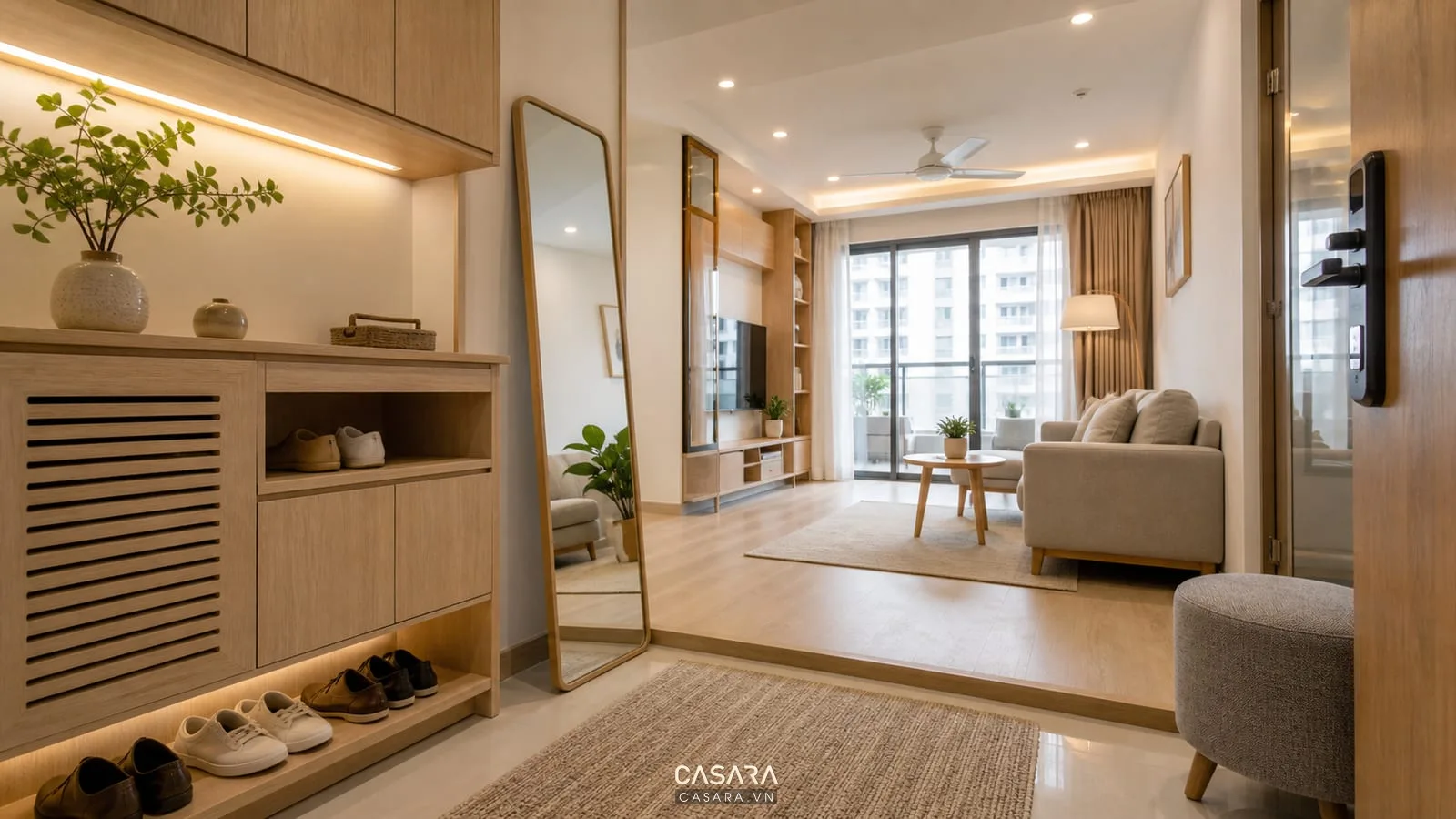 Lối vào chung cư 60m2 hiện đại có tủ giày gỗ sáng gương đứng sofa nhỏ và ánh sáng ấm