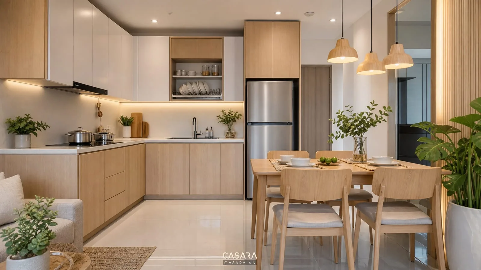 thiết kế nội thất chung cư bcons với bếp mở tủ bếp chữ L bàn ăn bốn ghế đèn thả và vật liệu gỗ sáng