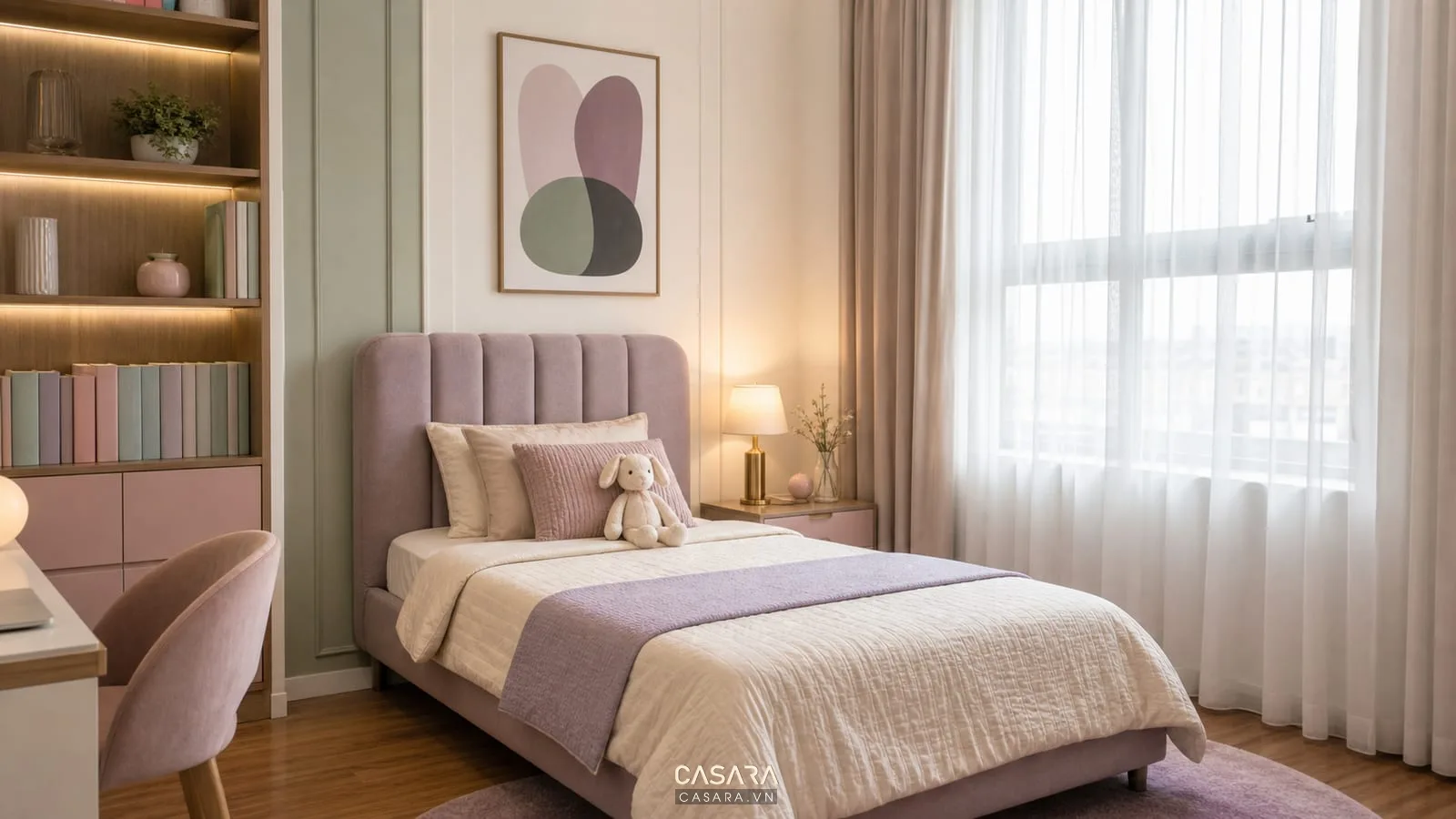 Phòng ngủ cho bé gái màu pastel với giường đơn đầu giường bọc nệm, rèm voan trắng, tranh treo tường, đèn ngủ ánh vàng và kệ sách thấp cạnh giường