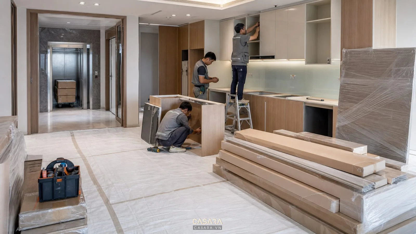 thi công chung cư với sàn che bảo vệ thang hàng vật tư nội thất tủ bếp đang lắp đặt và đội thợ gọn gàng